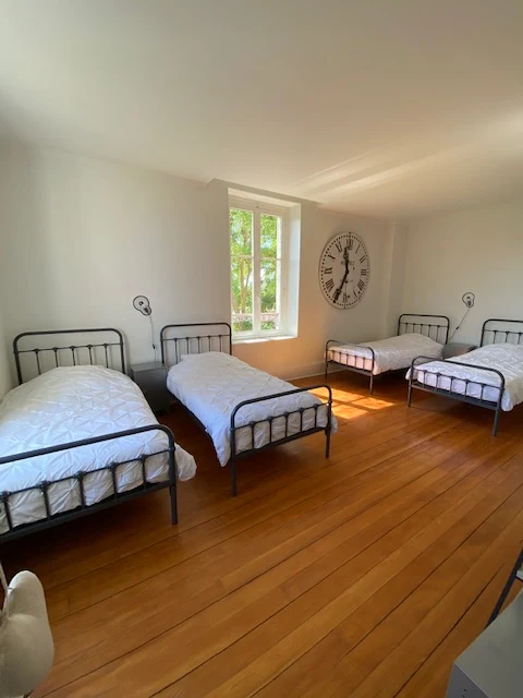 Chambre 4 : les quatre lits en métal noir face à la fenêtre, appliques noires orientables au mur