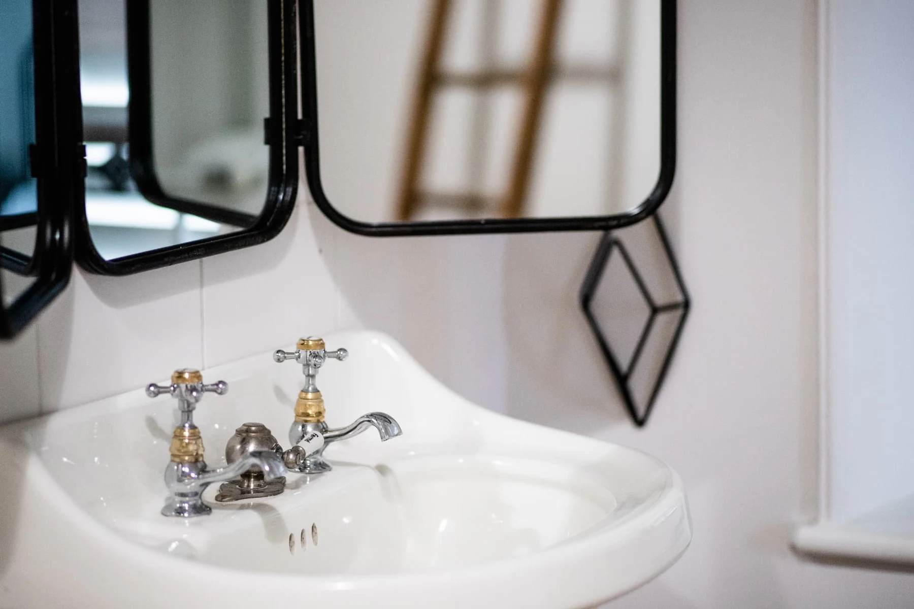 Lavable en porcelaine avec robinets à crosses dorées et miroirs à cadre noir