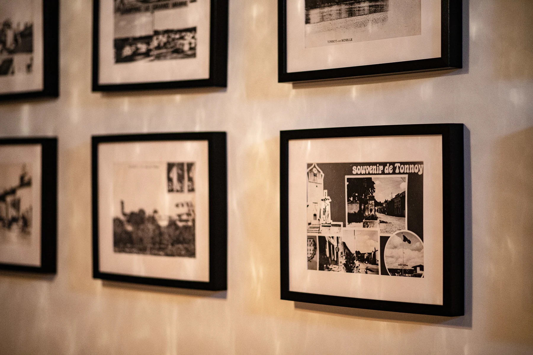 Photographies anciennes de Tonnoy encadrées sur le mur du hall